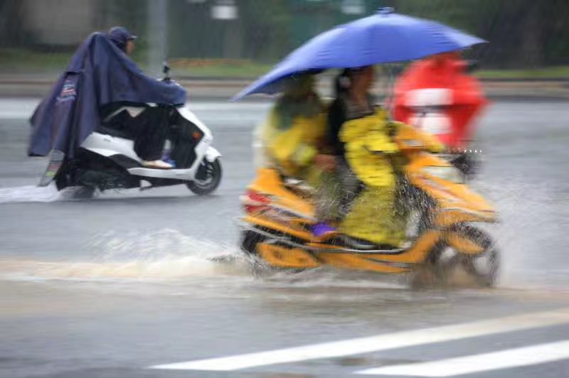 2017年6月24日，黄山市屯溪区市民冒着暴雨骑车行驶在积水的城市道路上，图片：潘成.jpg